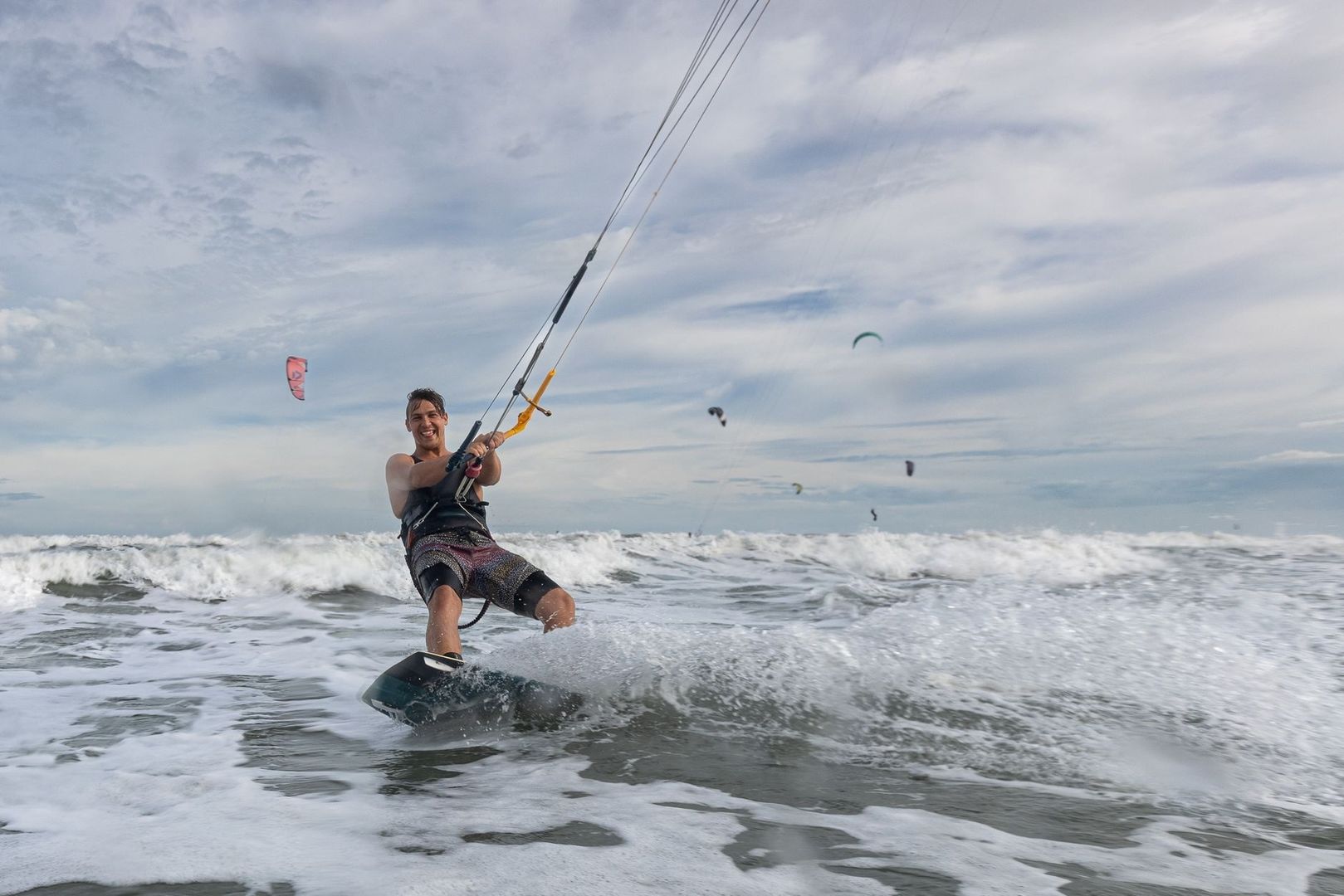 Kitesurfeur strapless glissant sur une planche au-dessus des vagues